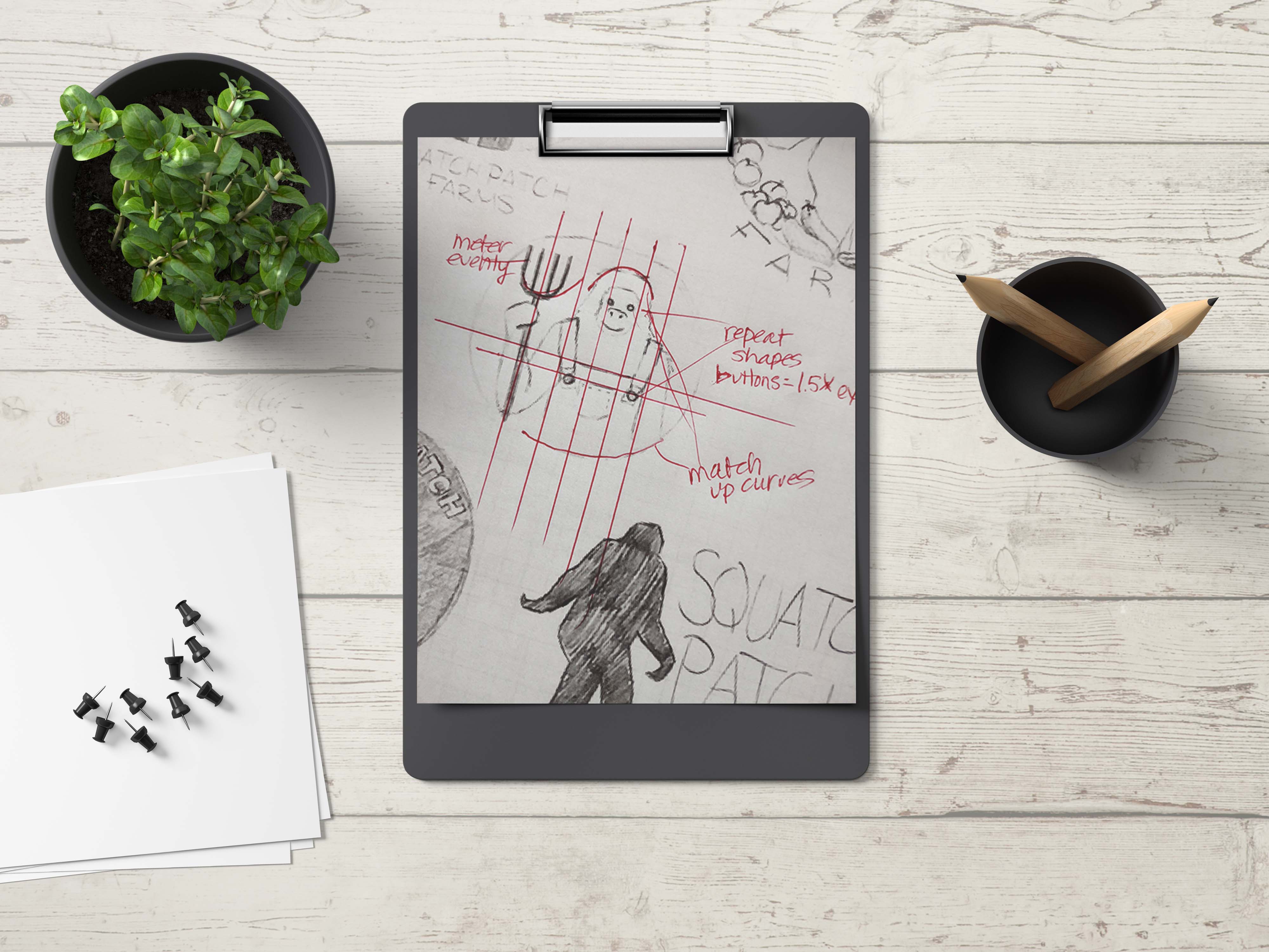 Clipboard on a desk with a plant, thumbtacks and a pencil cup. The clipboard has a design with feedback.